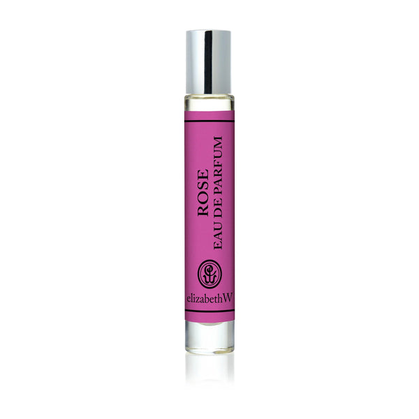 The elizabeth W Signature Rose Rollerball is a floral fragrance in a sleek glass bottle with a shiny silver cap and a pink label featuring “ROSE EAU DE PARFUM” and the elizabeth W logo at the bottom.