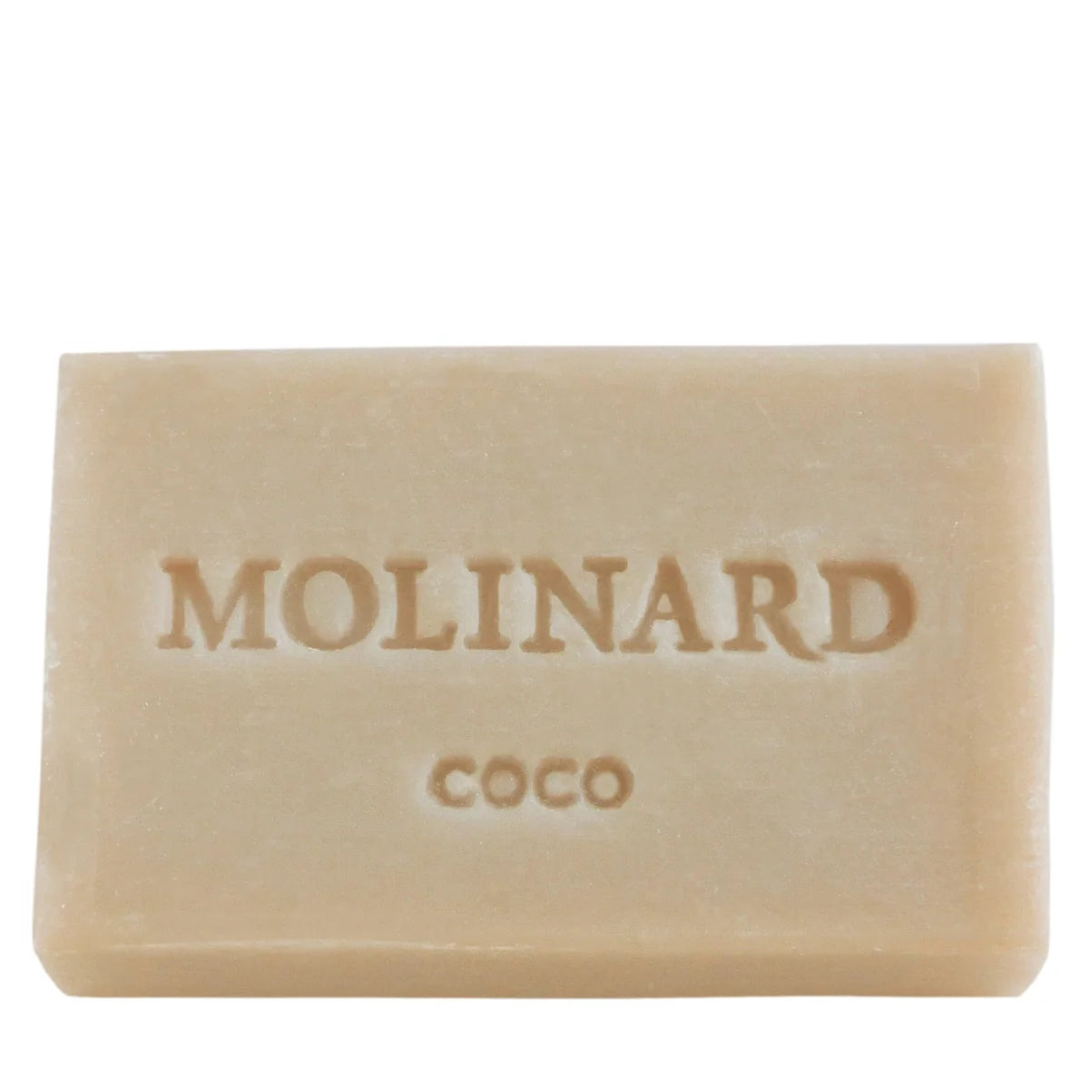 A beige rectangular Molinard Soap - Coconut bar, engraved with "Molinard" and "Coco," pays tribute to the French perfumery heritage.