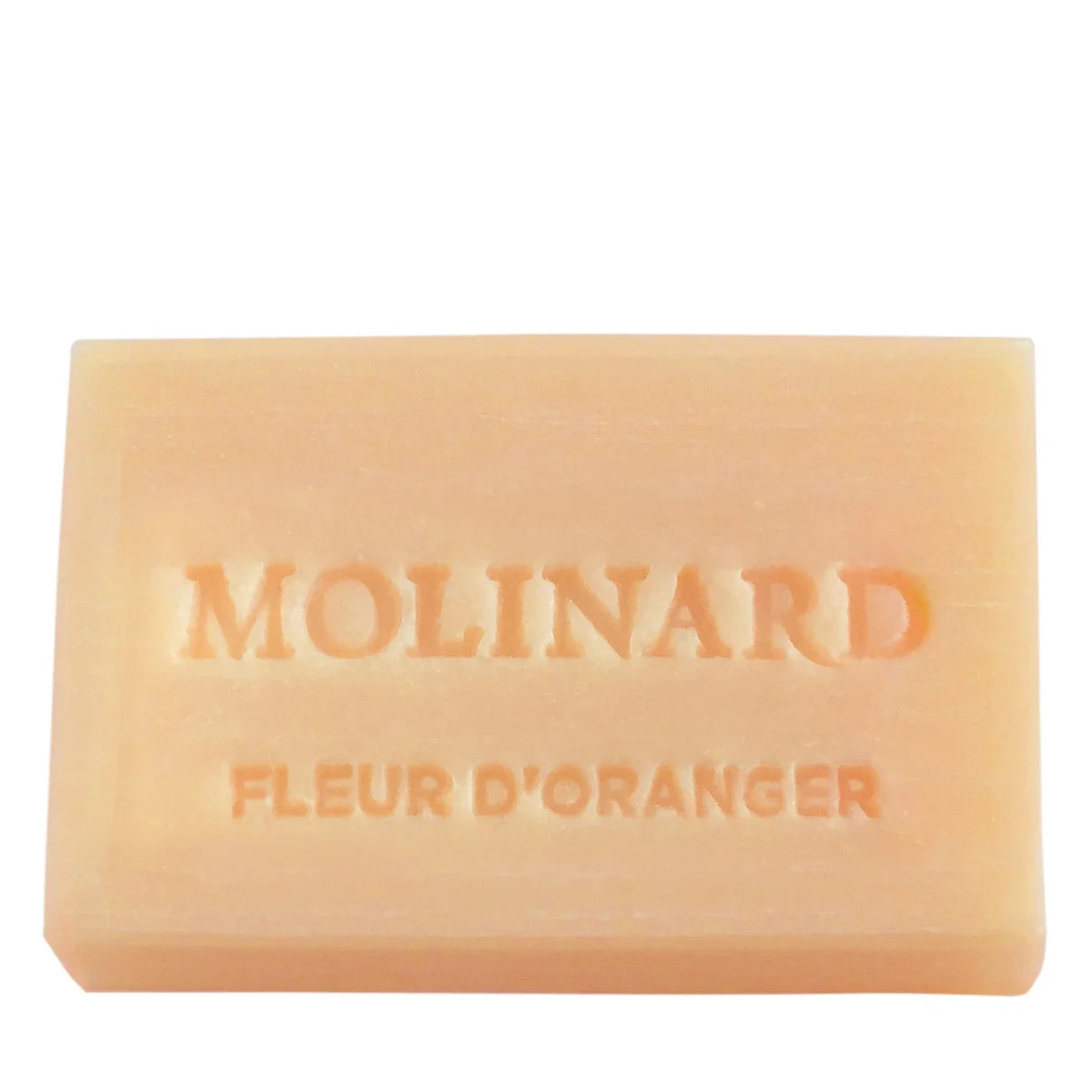 The Molinard Soap - Orange Blossom is a rectangular pale orange bar engraved with "MOLINARD FLEUR D'ORANGER," reflecting the refined elegance of Grasse perfumery.