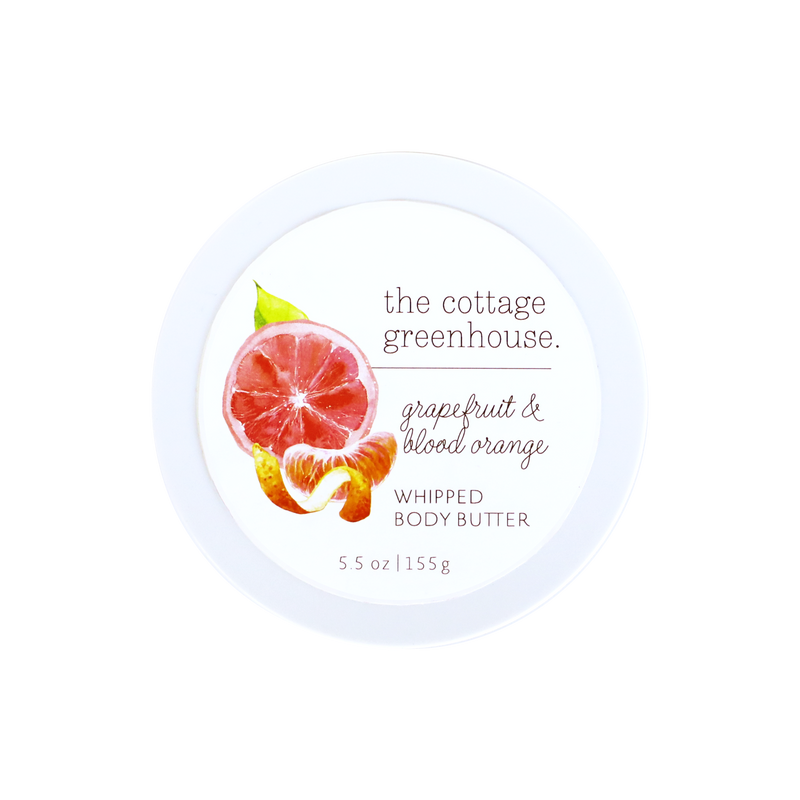 The Cottage Greenhouse Grapefruit & Blood Orange Body Butter by Margot Elena comes in a round white 5.5 oz container with watercolor citrus art on the lid, emphasizing this natural, moisturizing formula.