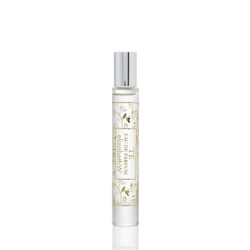 A sleek elizabeth W Signature Té Rollerball perfume bottle with a clear design featuring a white label adorned with elegant golden botanical illustrations and the name 'Elizabeth W Signature Té' in sophisticated typography.