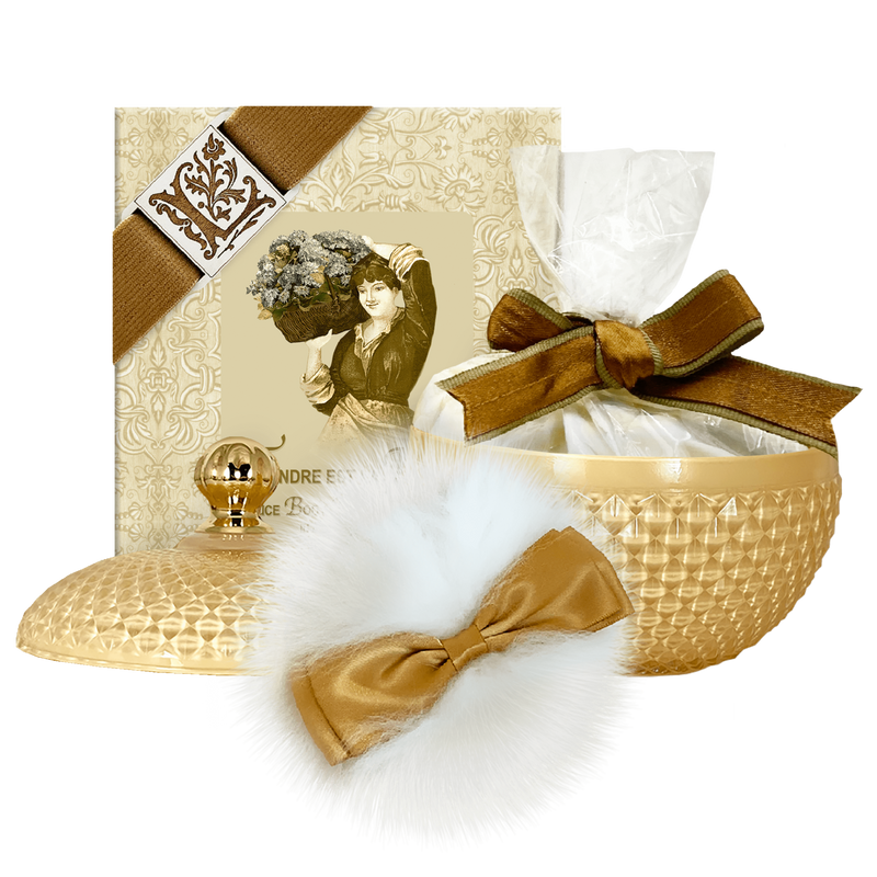 An elegant gift set featuring a round, golden basket with a white fluffy bow, a cream ribbon, and a vintage-style box of La Bouquetiere Tendre est la Nuit Rice Body Powder, Puff & Glass Dish
