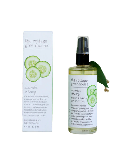The Cottage Greenhouse Cucumber & Honey Dry Oil Body Spray by Margot Elena comes in vegan-friendly packaging adorned with cucumber slices, designed to refresh and hydrate your skin with therapeutic properties.
