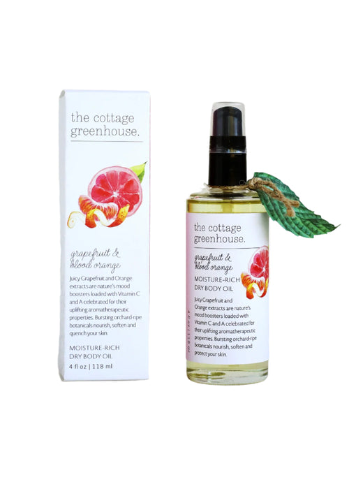 A bottle of Margot Elena's The Cottage Greenhouse Grapefruit & Blood Orange Dry Oil Body Spray features a spray nozzle and citrus illustration. Ideal for skin conditioning, it comes with a vibrant branded box that mirrors the design.