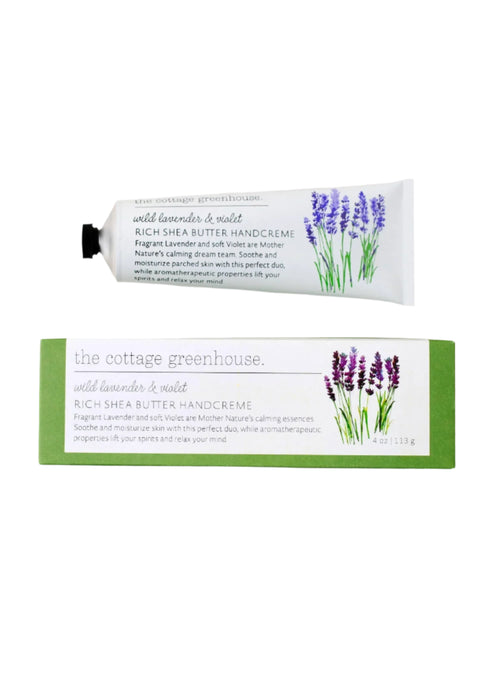 A tube and box of Margot Elena's "The Cottage Greenhouse" Wild Lavender & Violet Handcreme with avocado oil, enriched with shea butter. The packaging features charming lavender illustrations, emphasizing its nourishing qualities.