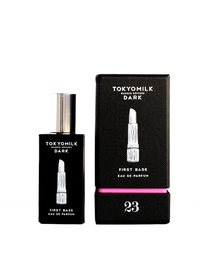 Black glass perfume bottle labeled "Margot Elena TokyoMilk Dark First Base No. 23 Eau De Parfum" next to its textured box with a pink accent and Cedarwood note, number 23 displayed prominently.
