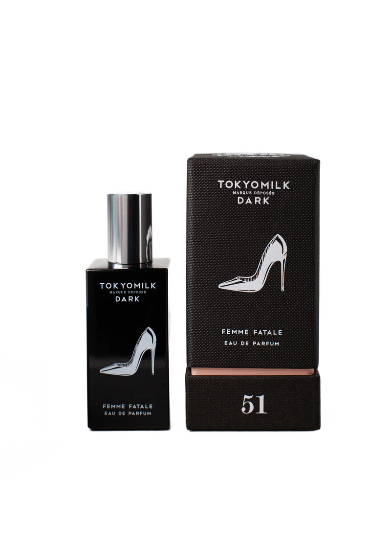 A bottle of Margot Elena's TokyoMilk Dark Femme Fatale No. 51 Eau De Parfum next to its black packaging box decorated with a white high heel shoe graphic and the number 51.