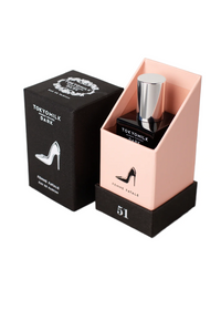 A perfume bottle labeled "TokyoMilk Dark Femme Fatale No. 51 Eau De Parfum" sits inside a pastel peach box with a matching black outer box, both adorned with an elegant high heel graphic. This Margot Elena.