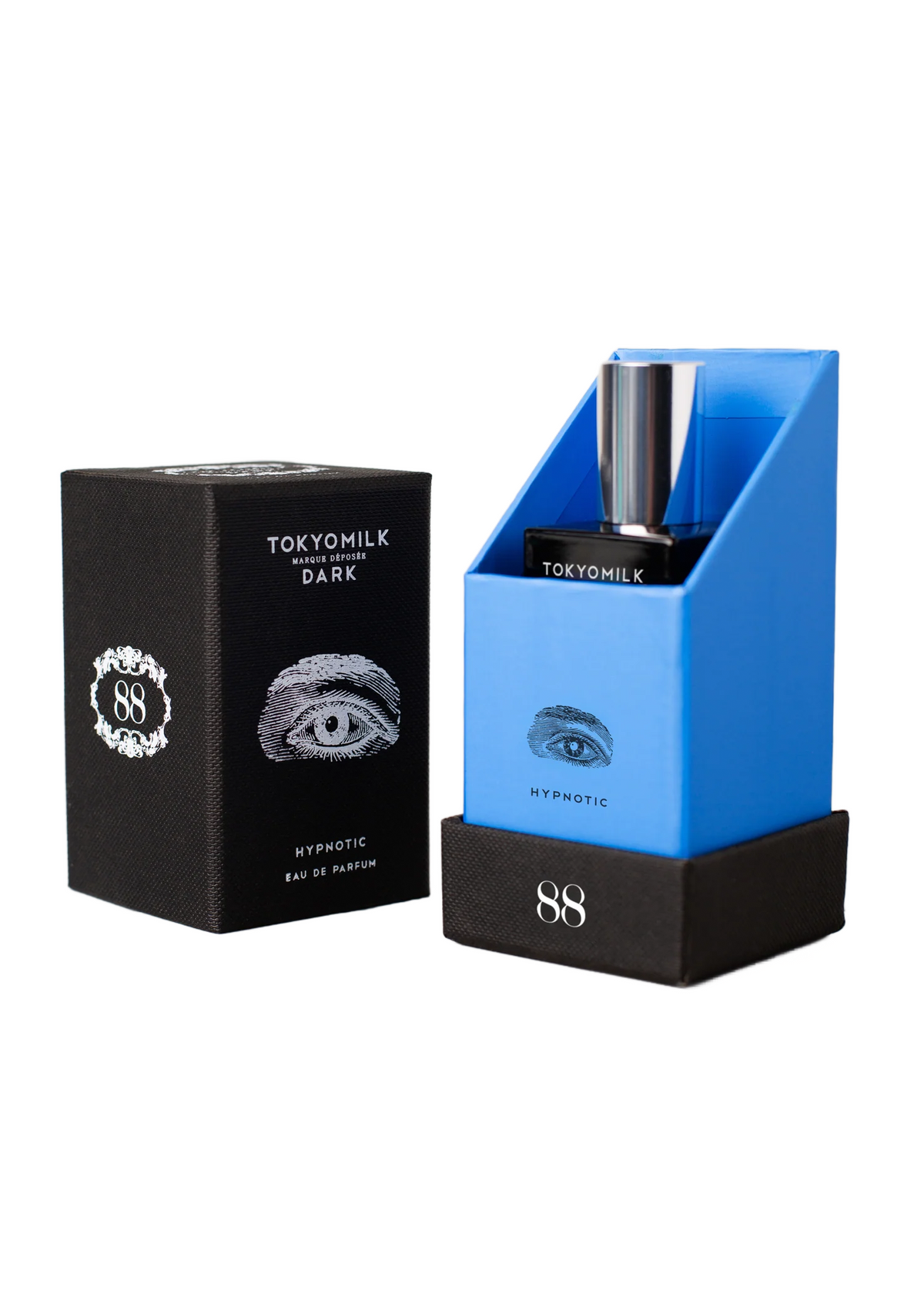 Two Margot Elena TokyoMilk Dark Hypnotic Eau De Parfum products: a black box labeled "hypnotic," featuring a stylized eye emblem, alongside an open blue box displaying a silver