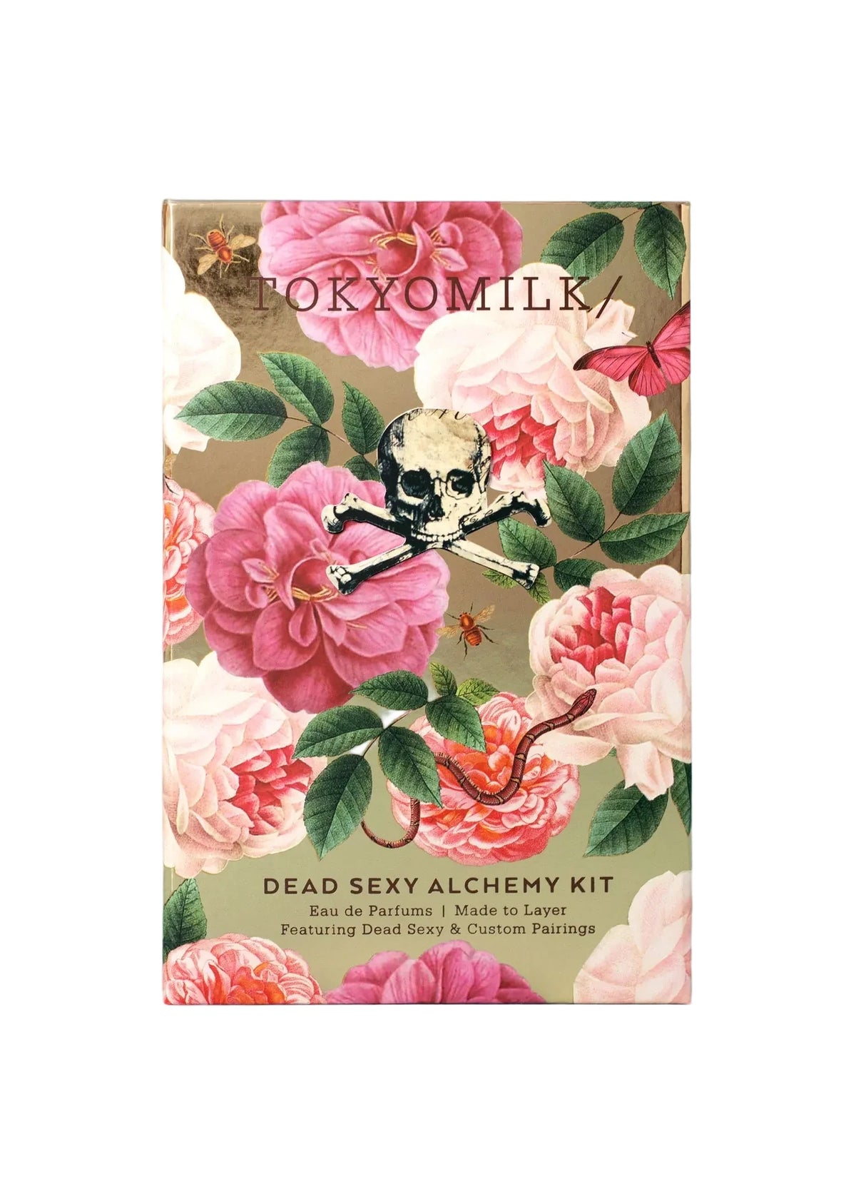 A rectangular box from Margot Elena featuring pink and red flowers, a skull and crossbones, a snake, and “TokyoMilk Dead Sexy Alchemy Kit”—perfect for fragrance layering with unique Eau de Parfum details.