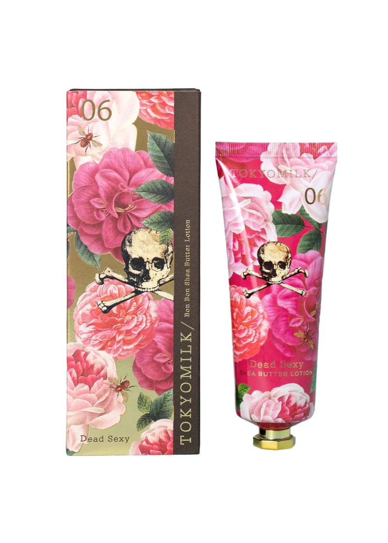 The Margot Elena TokyoMilk Dead Sexy Large Handcreme features vibrant packaging with pink flowers, a skull and crossbones, and the number 06—perfect for intense hydration and bold style. Box and tube are both labeled "Dead Sexy.