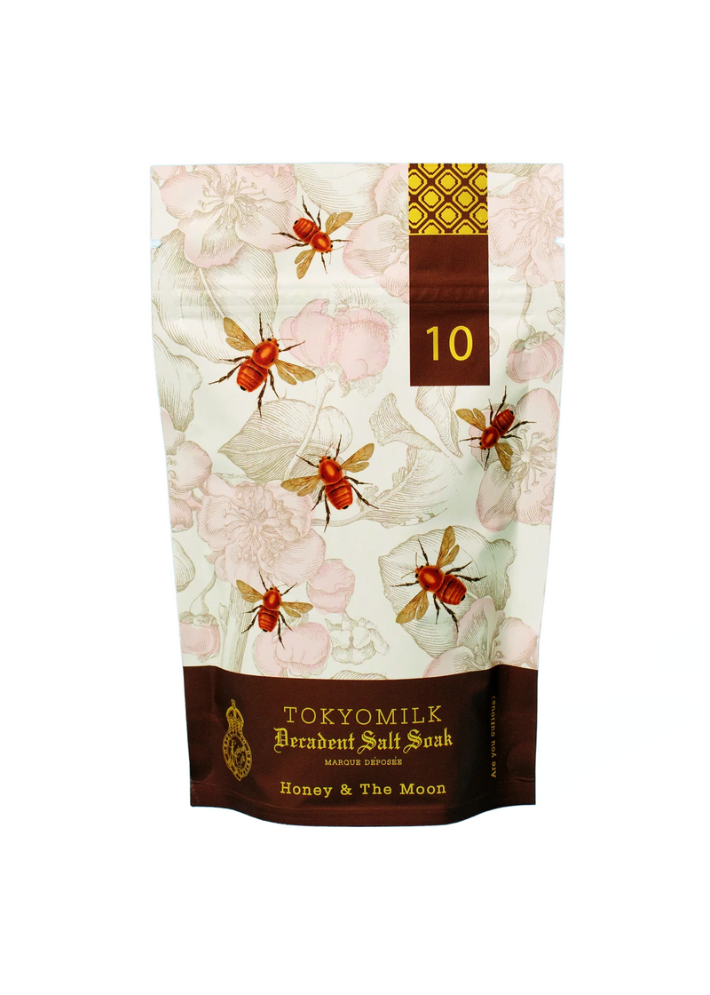A bag of Margot Elena brand TokyoMilk Honey & The Moon Salt Soak with floral and dragonfly designs, titled "honey & the moon no. 10." The packaging features soft pink blossoms.
