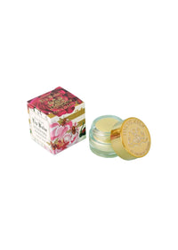 A small glass jar of Margot Elena's TokyoMilk Honeyed Apricot Lip Balm with a gold lid sits beside its decorative floral box, both displayed on a white background.