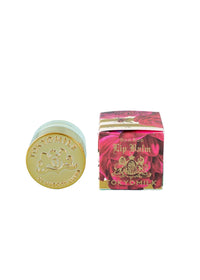 A small glass jar with a gold lid labeled "TOKYOMILK" sits beside a decorative box featuring red roses and gold text reading "Honeyed Apricot Lip Balm Margot Elena," offering luxurious care and lasting hydration.