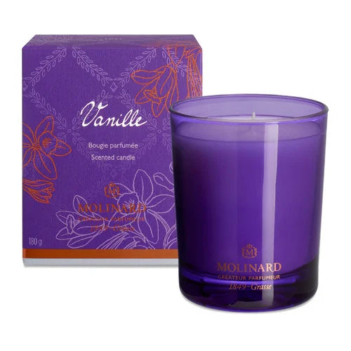 A purple glass Molinard Candle - Vanilla from Molinard sits beside its matching floral purple and orange box, both labeled "Scented candle" and "Vanille," for a touch of luxury home fragrance.