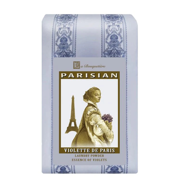 The La Bouquetiere Violette de Paris Laundry Powder comes in vintage biodegradable packaging, featuring a classic illustration of a woman with flowers, the Eiffel Tower in the background, and intricate decorative patterns on the sides.