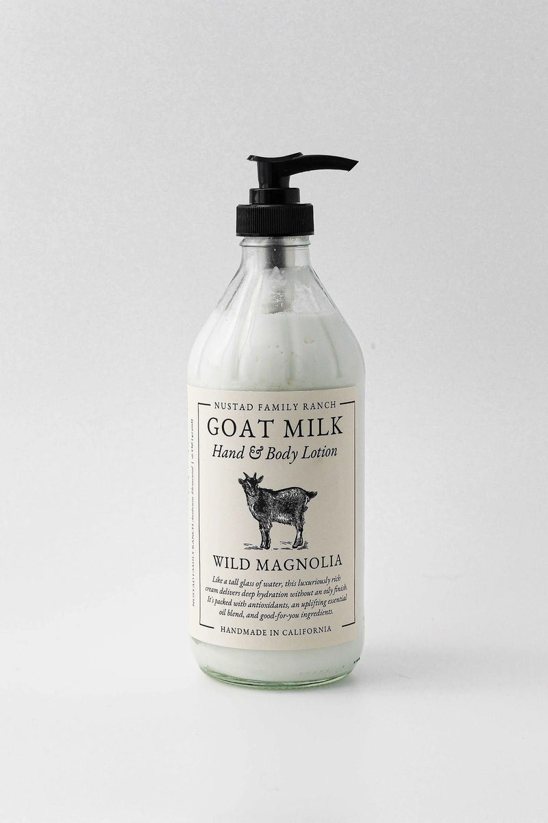 A clear bottle of Nustad Family Ranch Wild Magnolia Goat Milk Lotion with a black pump dispenser, labeled "wild magnolia," against a plain white background.