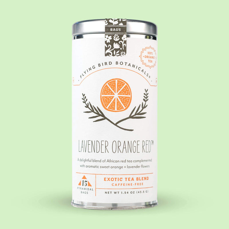 A cylindrical canister of Flying Bird Botanicals Lavender Orange Red – 15 Tea Bag Tin, featuring an elegant design with illustrations of organic orange peel and lavender on a light green background.