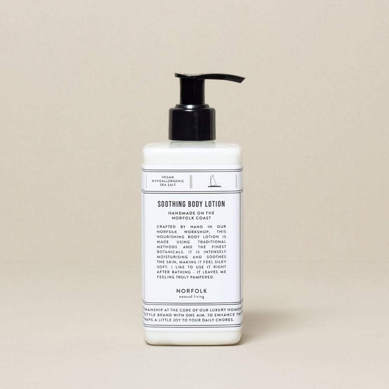 A bottle of Norfolk Natural Living Coastal Soothing Body Lotion - 300ml with a pump dispenser, labeled vegan and handmade in Norfolk, against a neutral background.