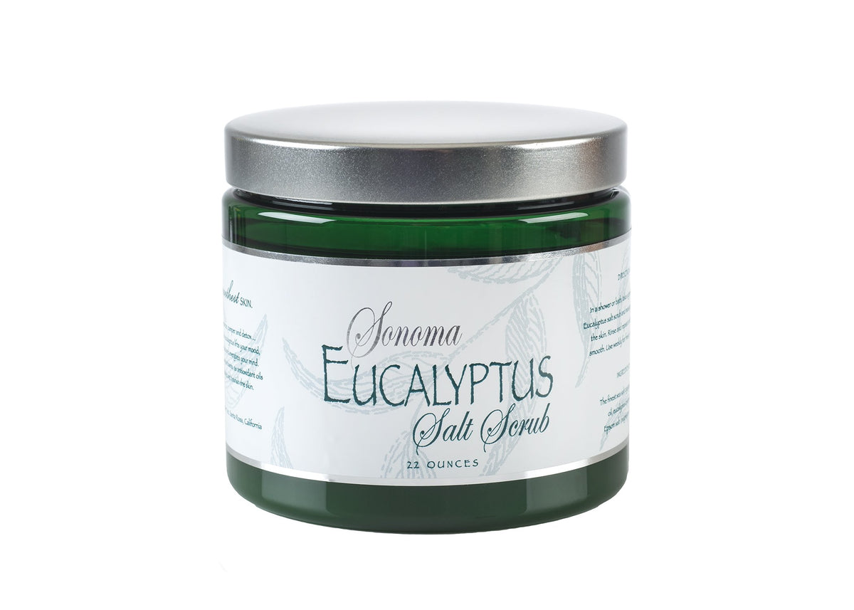 A jar labeled "Sonoma Eucalyptus Sea Salt Scrub" containing a green product, capped with a silver lid, isolated on a white background.