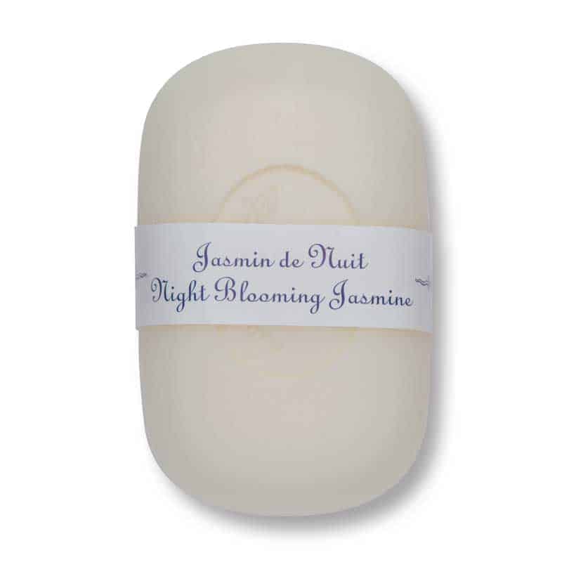 A bar of La Lavande curved bar soap wrapped with a label that reads "jasmin de nuit, night blooming jasmine" against a plain white background.