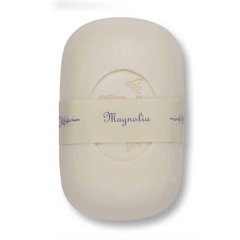 A single ivory-colored bar of La Lavande Curved Bar Soap - Magnolia - 100gm wrapped in a paper band labeled "magnolia" with floral detailing, displayed on a plain white background.