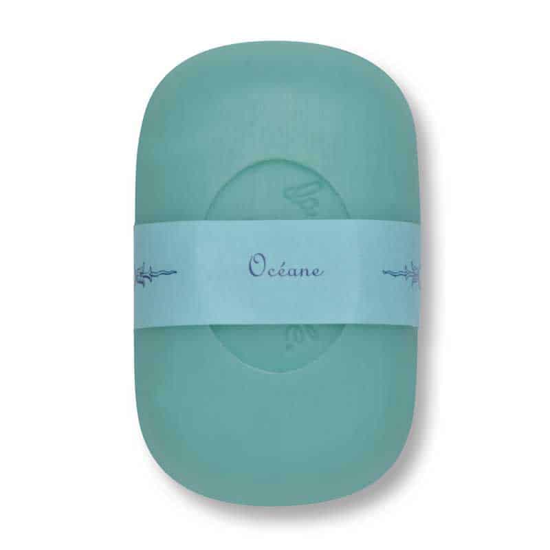 A single La Lavande Curved Bar Soap in Oceane scent with a mint green color and a white wraparound label featuring the word "océane" in a cursive script. The label is decorated with small, simplistic sea wave designs.