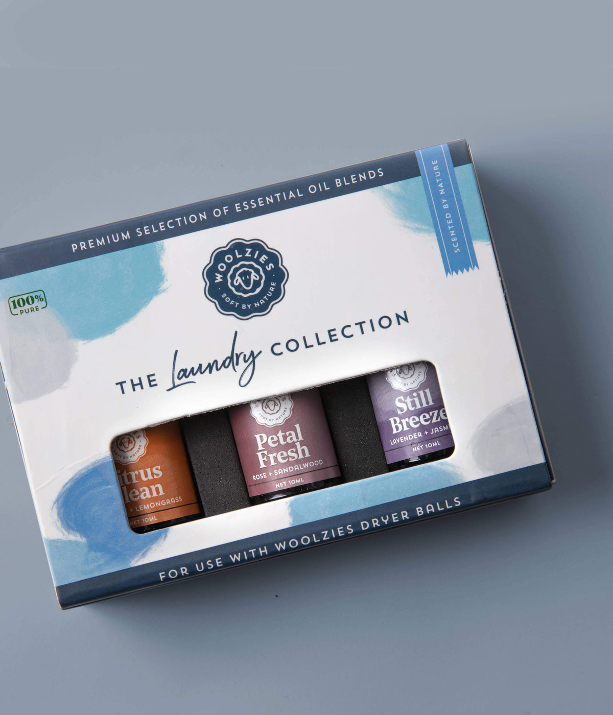A box labeled "Woolzies The Laundry Essential Oil Collection" containing three essential oil blends: citrus clean, petal fresh, and still breeze, specifically designed for use with Woolzies wool dryer.