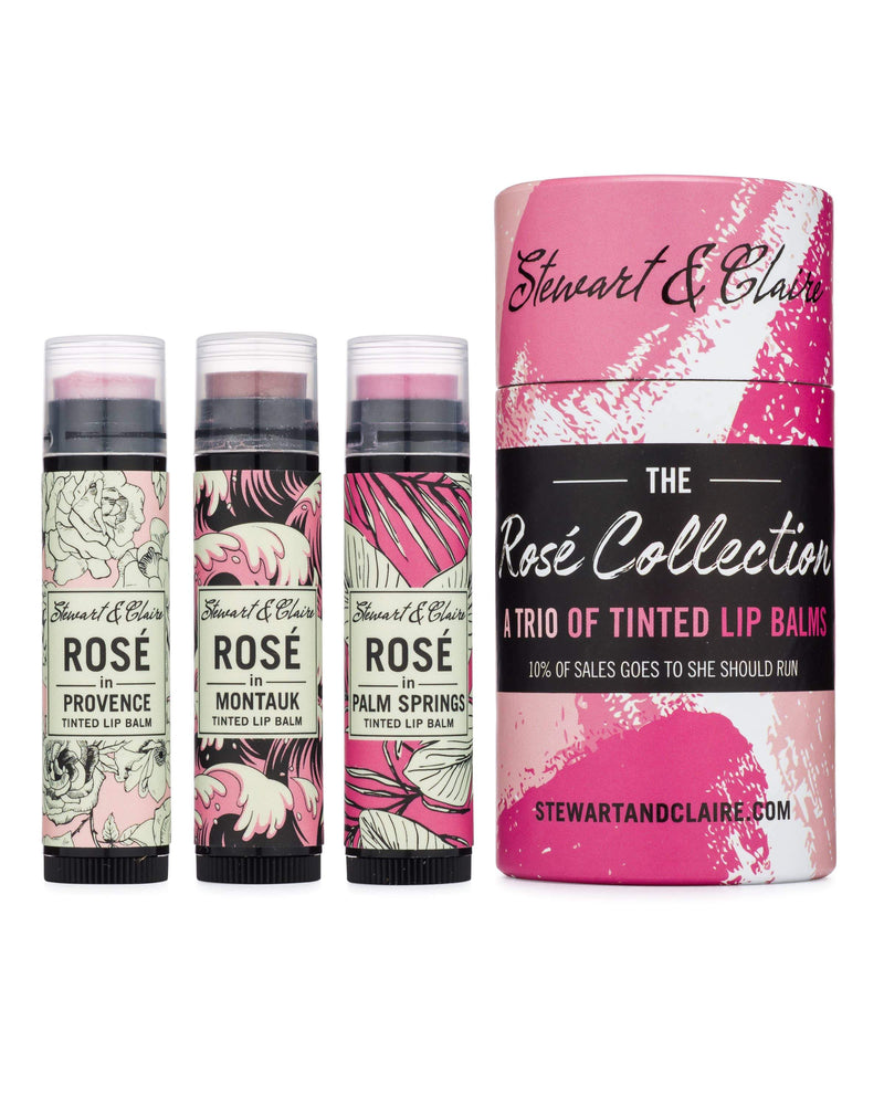 Four tubes of tinted lip balms from Stewart & Claire's The Rosé Collection featuring floral designs, with names like Provence, Montauk, and Palm Springs. Each balm