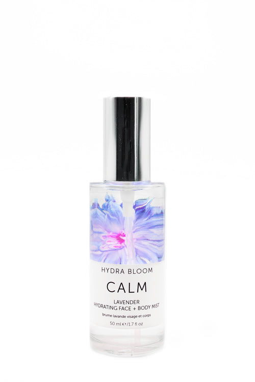 A bottle of "Hydra Bloom Beauty Lavender Calm" face and body mist, with a floral design, isolated on a white background.