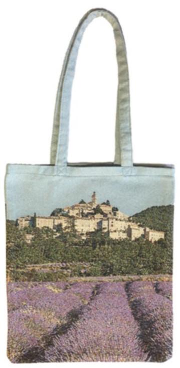 A Mierco woven European tote bag made in Portugal featuring a printed image of a scenic landscape with lavender fields in the foreground and a historic village with a prominent church tower in the background.
