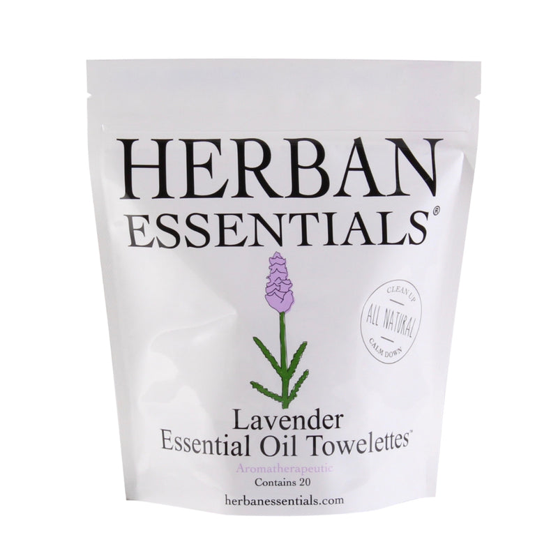 A white package of Herban Essentials Essential Oil Towelettes - Lavender with a lavender flower illustration. The label states "all natural" and provides a website.