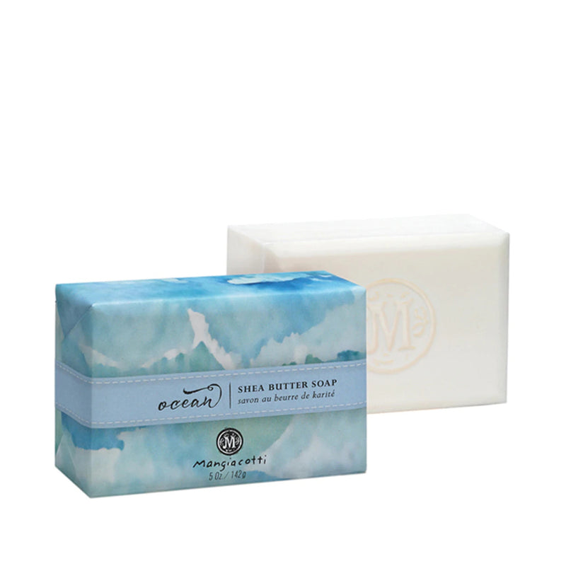 Two bars of Mangiacotti Ocean Shea Butter Bar Soap, one in packaging labeled "ocean" with a blue and white design, and one unwrapped, plain white.