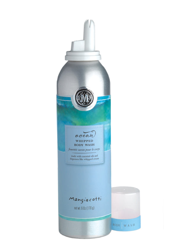 A silver and blue pressurized body wash can labeled "Mangiacotti Ocean Whipped Body Wash" with an open cap next to it, on a white background, containing whipped body wash.