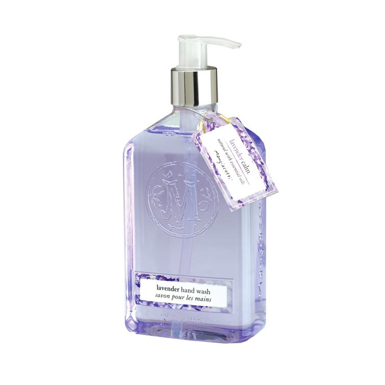 A clear bottle of Mangiacotti Lavender Liquid Hand Wash infused with essential oils, featuring a pump dispenser. The bottle has a decorative, embossed emblem and is adorned with a purple tag that includes product details.