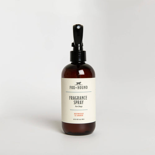 A brown glass bottle of "Fox + Hound Redwood & Amber Spray Cologne" with a black pump, labeled prominently, against a plain white background.