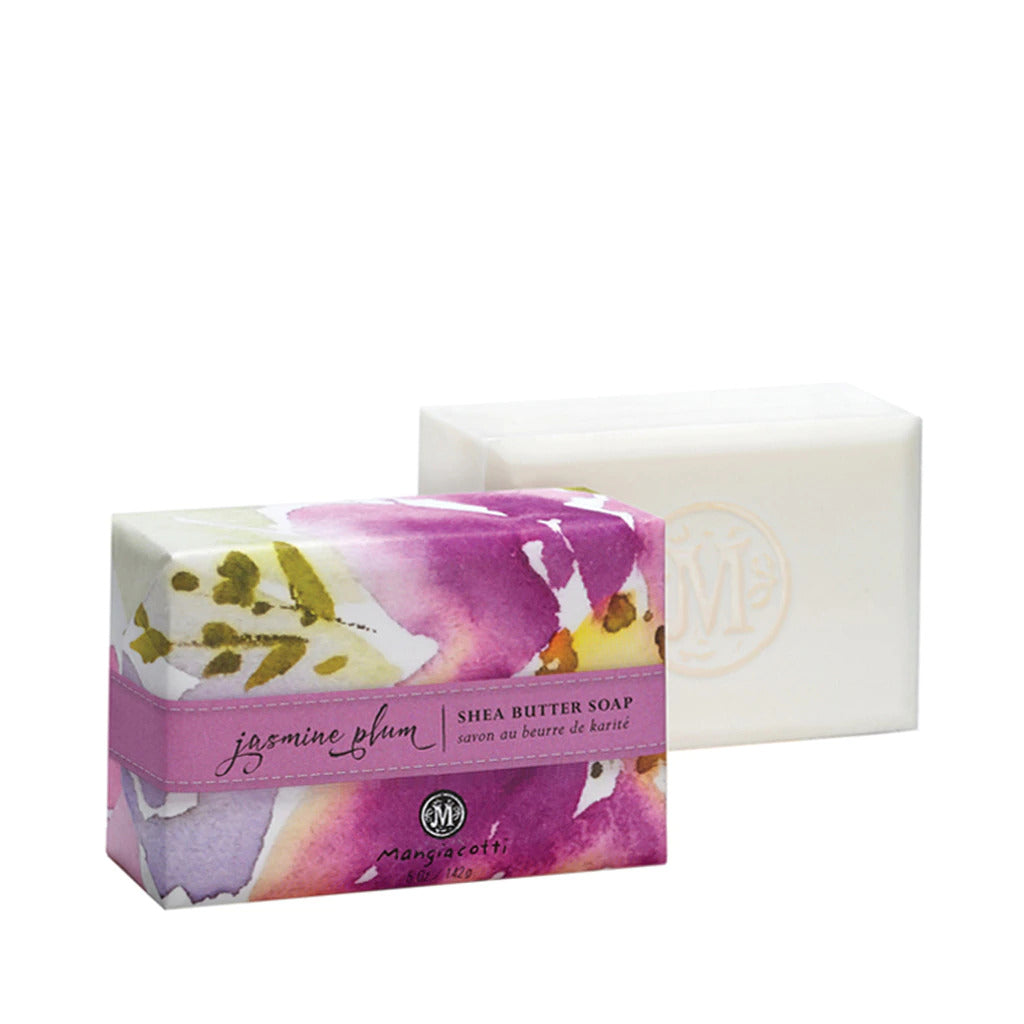 A package of Mangiacotti Jasmine Plum Shea Butter Bar Soap alongside a white triple-milled body bar, with floral designs and pink detailing on the packaging.