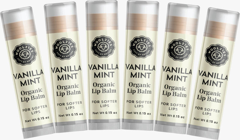 Five tubes of Woolzies Vanilla Mint Lip Balm aligned in a row, with text describing the product as for softer lips. Each tube features a floral emblem and is slightly translucent.