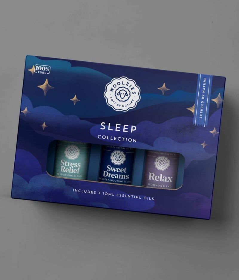 A box of "Woolzies The Deep Sleep Essential Oil Collection" depicting a dark blue starry background. The box includes three labeled bottles: stress relief oil blend, sweet dreams oil blend, and relax.