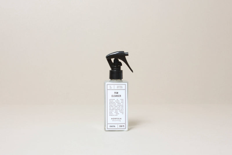 A minimalist bottle of Norfolk Natural Living Coastal Paw Cleanser 200ml with a black spray nozzle, labeled in a simple black and white design on a neutral background.