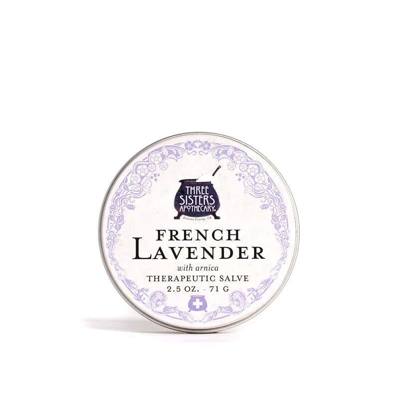 A round tin of "Three Sisters Apothecary French Lavender Therapeutic Salve with Arnica" displayed on a white background, showcasing elegant label design with floral motifs.