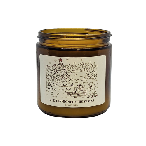 The Fox + Hound Odor Eliminator Soy Candle - Old Fashioned Christmas comes in an amber glass jar with a festive label and fills your space with a cozy holiday scent while helping eliminate odors.