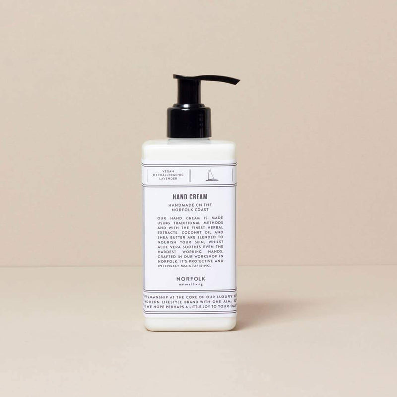 A white pump bottle of Norfolk Natural Living Lavender Hand Lotion enriched with herbal extracts, against a plain beige background. The label features a clean, minimalistic design with text detailing the product's ingredients and benefits.