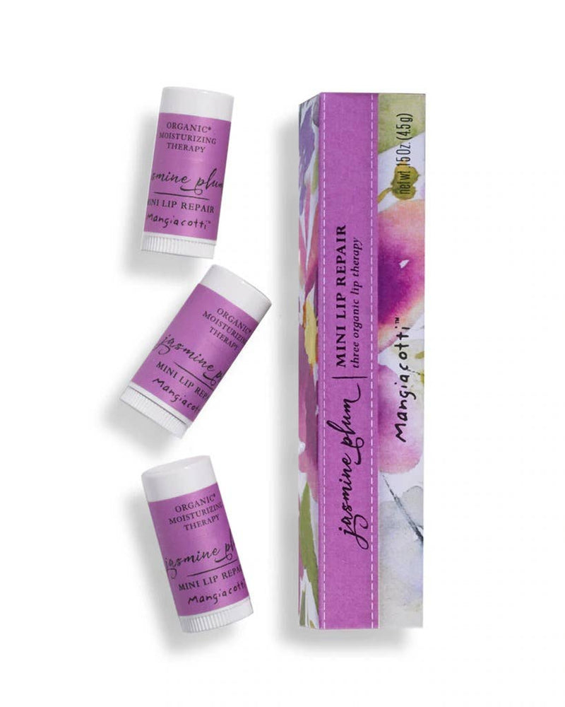 Two tubes of Mangiacotti jasmine plum mini lip repair next to their corresponding purple and floral printed gift boxes. The products are labeled "Mangiacotti" and highlighted as "mini lip repair".
