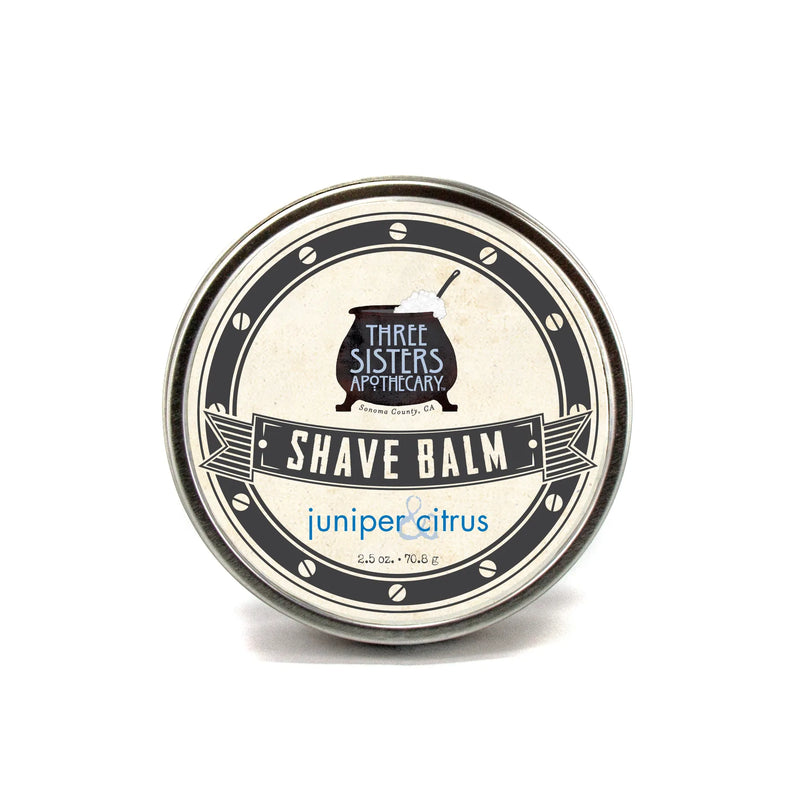 A round tin of Three Sisters Apothecary Shave Balm - Juniper & Citrus, displayed on a white background. The label features a vintage style with black and grey colors and is formulated with essential.