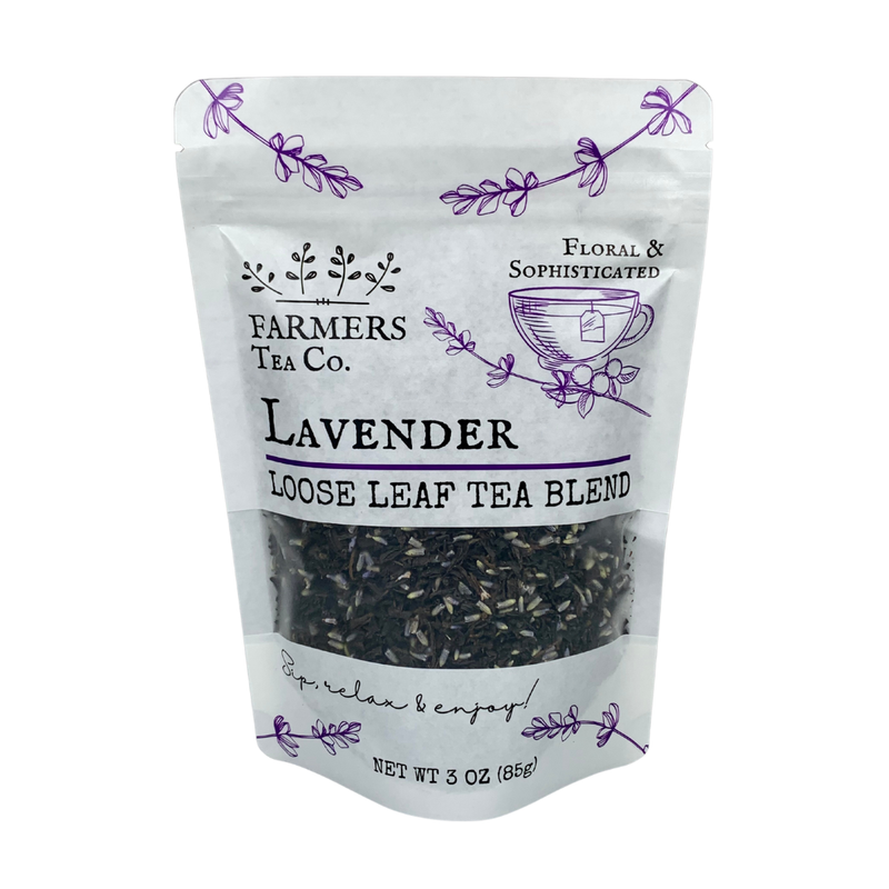 A package of FARMERS Lavender Co. lavender loose leaf tea blend, showing visible tea leaves inside a white pouch with floral designs and purple text.