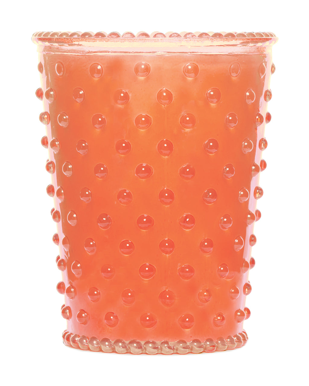 A vibrant orange Simpatico NO. 71 GUAVA Hobnail Glass Candle with a dotted hobnail texture pattern all around, isolated on a white background.