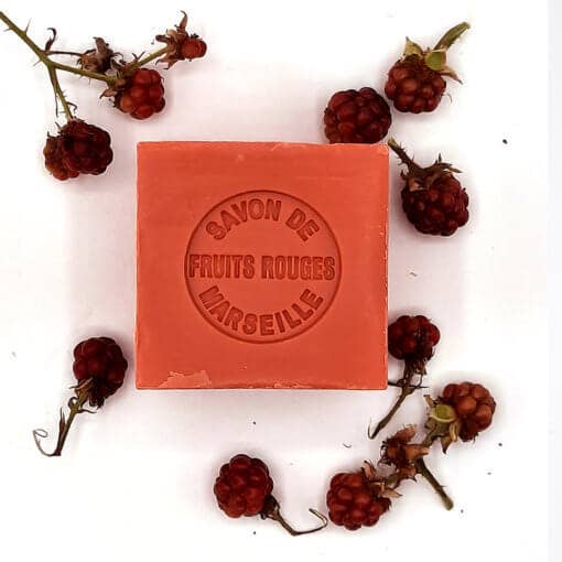 A square, red Senteurs de France Marseille Soap Red Fruits soap bar surrounded by fresh blackberries on a white background.