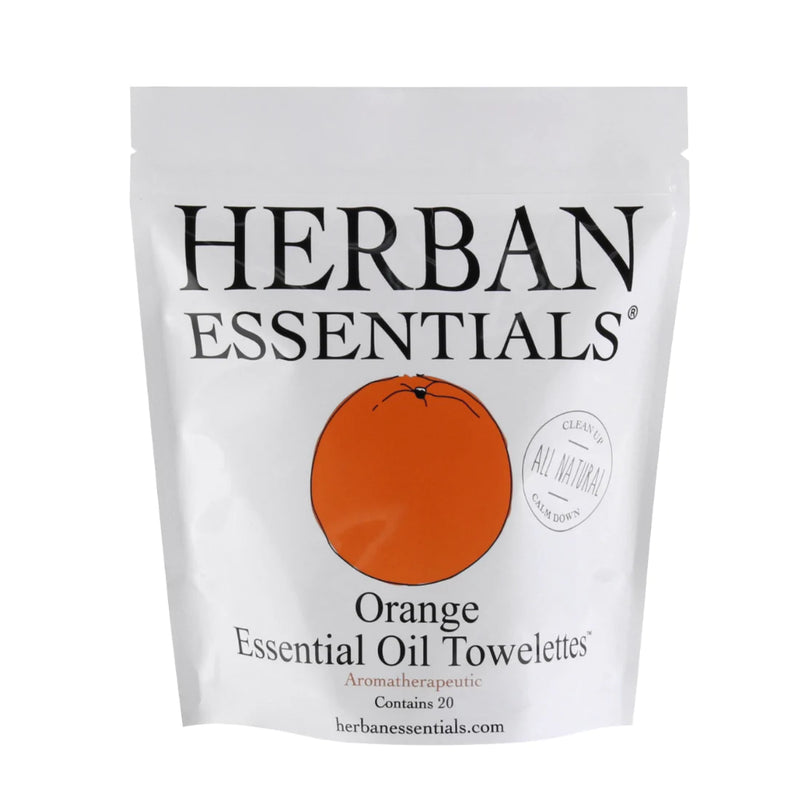 A white pouch labeled "Herban Essentials" with "Herban Essentials Essential Oil Towelettes - Orange Mini-Bag" in black text and an orange circle on the front, illustrating the scent. Contains 20 wipes enriched with a