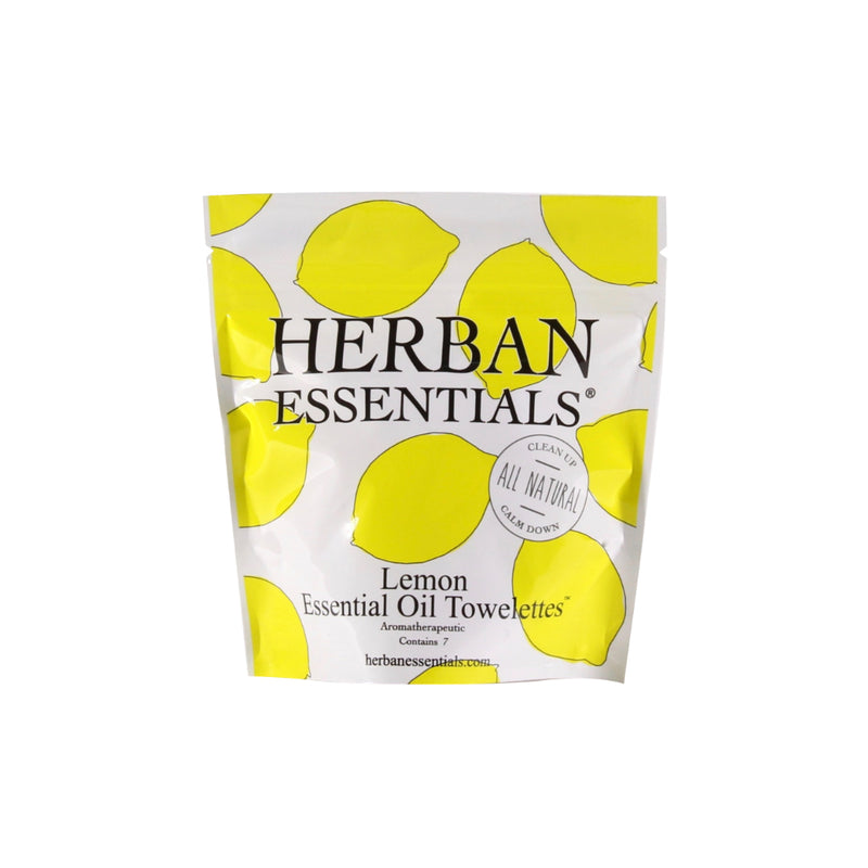 A packet of Herban Essentials Essential Oil Towelettes - Lemon Mini-Bags, featuring lemon essential oil towelettes with yellow lemon slices on a white background. The text emphasizes clean hands and all-natural ingredients.